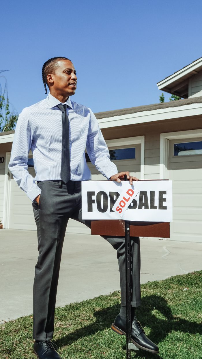 Mastering the First Impression: Your intriguing post title goes here Realtor standing beside a sold sign in front of a new home.