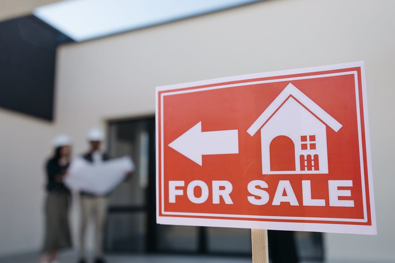 Crafting Captivating Headlines: Your awesome post title goes here A real estate sign indicates a property for sale as two agents in hard hats discuss building plans outdoors.